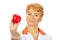 Smile elderly female doctor or nurse holding red toy heart