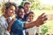 Smile everyone. a group of friends taking a selfie together outdoors.