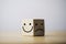 Smile face in bright side and sad face in dark side on wooden block cube for positive mindset selection concept