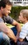 Smile, father and boy sitting on grass, cute bonding together with care and love in home backyard. Outdoor fun, dad and