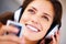 Smile, headphones and closeup of young woman listening to music, playlist or radio at home. Happy, technology and face