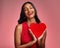 Smile, heart and valentines day with a woman on a pink background in studio for love or romance. Eyes closed, emoji and