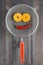 Smile made with peeled mandarine tangerine as eyes, pepper chili mouth in metal sieve colander