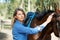 Smile, nature and portrait for woman with her horse on an outdoor farm for sports racing. Grooming, training and