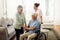 Smile, old man in wheelchair with wife and nurse at nursing home for disability help and rehabilitation. Healthcare