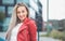 Smile portrait of a young woman looking to side. Outdoors daylight. Half length of cute girl wearing casual clothing