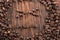 Smile shaped of roasted coffee beans on white wood background