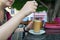 Smile unrecognizable woman stir spoon in a terrace of a cafeteria, sitting and talking with friends, having a good moment.