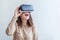 Smile young woman wearing using virtual reality VR glasses helmet headset on white background. Smartphone using with virtual