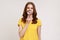 Smile, zoom, tooth care. Portrait of young aged woman in casual yellow T-shirt standing and holding magnifying glass on her teeth