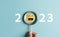 Smiley face on 2023 year concept. Magnifier focus to yellow emoticon face. happy to next year from end 2022, New year