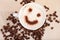 Smiley Face In Cappuccino With Coffee Beans On Table