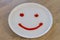 Smiley face of tomato source on white plate