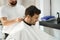 Smiley hair salon guest enjoying his haircut appointment