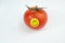Smiley happy face on fresh organic red tomato isolated on white background