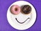 Smiley happy face made on dish with donuts eyes and chocolate syrup as smile in sugar and sweet addiction nutrition