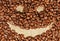 Smiley painted on coffee beans, horisontal view