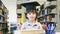 Smiley white boy with the Graduation cap and diploma paper stand