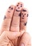 Smileys of family painted on man\'s fingers.