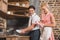 smiling 1950s couple washing and drying dishes together