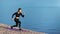 Smiling active girl training on mat outdoor having positive emotion. Wide shot on RED camera