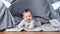 Smiling adorable little baby lying relaxing at home having positive emotion full shot