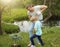 Smiling adult father and his son planting a tree outdoors in park.