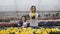 Smiling adult and young girls stretching flower pots to camera