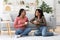 Smiling african american besties having conversation while drinking coffee