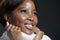 Smiling african american black woman looks up with hope, dreaming, feels happiness, inspiration. Closeup studio portrait