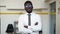 Smiling african american businesman in formal outfit looking at camera standing in office, arms crossed on chest