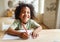 Smiling african american child school boy doing homework while sitting at desk at home