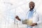 Smiling African American doctor using laptop and board