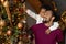 Smiling African American father piggy backing son, decorating Christmas tree