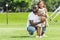 smiling african american father squatting and hugging daughter with teddy bear