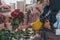 Smiling african american florist watering bouquet of beautiful flowers