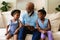 Smiling african american girls with african american grandfather showing digital tablet