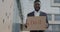 Smiling African American man holding Do It poster smiling motivating and inspiring standing outdoors in city