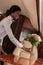 Smiling african american stewardess putting fresh flowers on table