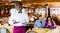 Smiling african american waiter inviting to taste dishes in restaurant