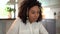 Smiling African American woman with headset using laptop at home office, in headphones with microphone