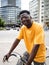 Smiling african american young man with a bicycle in the city. Sustainable mobility, millennial lifestyle