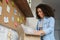 Smiling african girl customer opens parcel box at home.