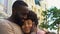 Smiling african man hugging girlfriend, loving couple nuzzling, outdoor date