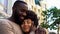 Smiling african man hugging girlfriend, loving couple, outdoor romantic date