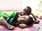 Smiling African Sisters Lying on Floor Smiling, Laughing Cheerful at the Camera