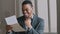 Smiling African stylish young guy black man businessman in modern office room alone read letter grand proposal exam