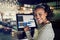 Smiling African waitress using a restaurant point of sale termin