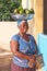 Smiling african woman with bowl on her head with ripe green avocados