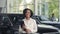 Smiling african woman posing at auto salon with clipboard